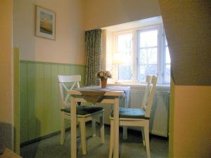 a dining room with a table and chairs and a window at Haus Arfsten "Schimmelreiter", Nieblum in Nieblum