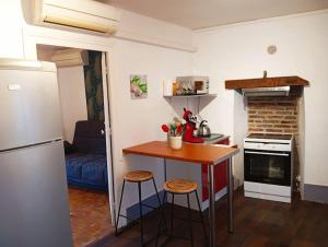 a small kitchen with a table and two stools at Halte de Saint Léger déplacements professionnels et familles in Saint-Léger-des-Vignes
