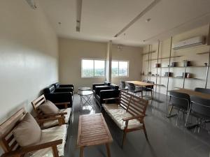 a living room with a couch and chairs and tables at Cozy Studio Condo Unit at Fullerton Suites in Silang