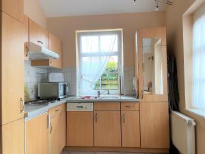 una cocina con fregadero y ventana en Gartenhaus, Mühlenstraße, en Wyk auf Föhr