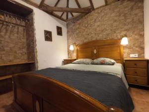 una camera con letto in legno e parete in pietra di Charming Canarian House at Villa Lila a Puerto de la Cruz