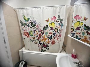 ein Badezimmer mit einem Duschvorhang mit Schmetterlingen darauf in der Unterkunft Apolonium Apartment Properties in Bukarest + 36 Fotos