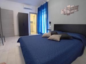 a bedroom with a blue bed with blue sheets and pillows at Affitti brevi TAORMINA in Realmonte