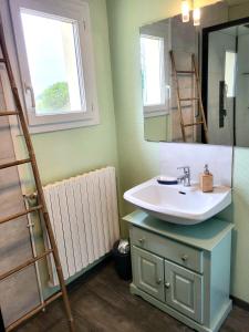 a bathroom with a sink and a mirror at Maison de bord de mer, les Fleurs in Créances +22 photos