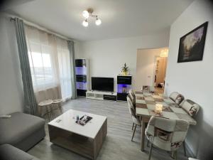 ein Wohnzimmer mit Tisch und Couch in der Unterkunft Apolonium Apartment Properties in Bukarest