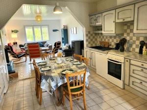 a kitchen and dining room with a table and chairs at Maison de bord de mer, les Fleurs in Créances