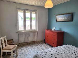 a bedroom with a bed and a dresser and a window at Maison de bord de mer, les Fleurs in Créances