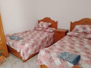 two beds sitting next to each other in a bedroom at شاليه بقرية القصر السياحية للايجار ب مطروح إمتداد شاطيء الأبيض حمام السباحة في القرية به صيانه in Marsa Matruh +21 photos