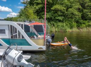 a man laying on a raft in the water next to a boat at Filippa in Eldenburg