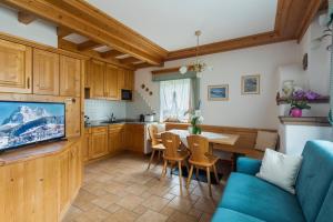 kuchnia i salon z niebieską kanapą i stołem w obiekcie Casa Piva Dolomiti w mieście Val di Zoldo