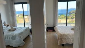 Un dormitorio con dos camas y vista al mar. en Villa Azur, en Le Lavandou 3 fotos más