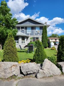 a house with a large rock in the front yard at Princess Motel in Bobcaygeon