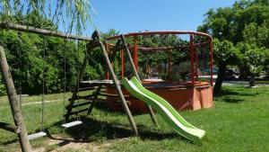 a playground with a green slide in a park at Camping Sud Ardèche 3 étoiles familial piscine chauffée Gorges de l Ardèche Saint Remèze in Saint-Remèze