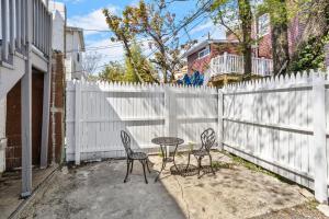 a patio with two chairs and a table and a fence at 9 Bedroom, 14 Beds House Great for Big Groups Near Boardwalk, Tropicana in Atlantic City