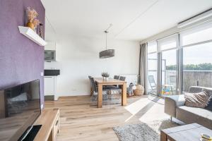 a living room with a table and a couch at Modern appartement met gratis fietsen in Breda