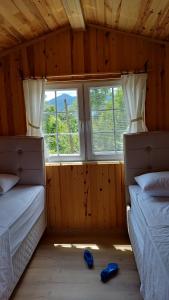 two beds in a room with a window at Cennet bahçesi in Yomra