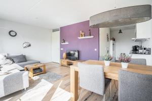a living room with a table and a couch at Modern appartement met gratis fietsen in Breda +4 photos