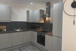 a kitchen with white cabinets and a stove top oven at Cozy Central Double Suite - Free Gym! in Leicester
