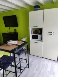 Una cocina con una mesa y un refrigerador blanco. en Studio au cœur de la Sologne, en Romorantin-Lanthenay