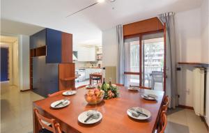 a kitchen and dining room with a table with fruit on it at Amazing Apartment In Lignano Sabbiadoro in Lignano Sabbiadoro