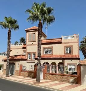 dom z dwoma palmami przed nim w obiekcie Large Villa private pool and garden near beach w mieście Roquetas de Mar