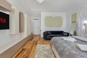 a bedroom with a bed and a couch at 59 Bleu H City Center Apart with FreeParking, AC, and an extra large comfy bed in Cluj-Napoca