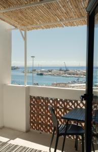 a table and chair on a balcony with a view of the ocean at Vico Concept Rooms in Termoli