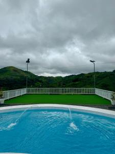 uma grande piscina azul com uma cerca branca em Remedios and Beverly Hills at Marilog, Buda em Kayagan