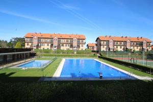 a large swimming pool in front of a building at Apartamento Guou in Comillas