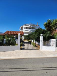 a white fence in front of a house at Garden House in Amarinthos