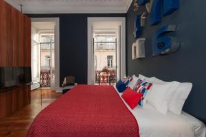 a bedroom with a bed with a red blanket on it at Lisbon Cheese & Wine Suites in Lisbon