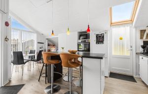 a kitchen with white walls and a bar with stools at Nice Home In Hemmet With Wifi in Hemmet