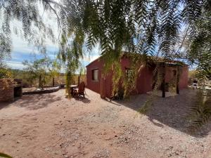 ein kleines rotes Haus mitten auf einem Feld in der Unterkunft Cabaña de campo Triasico in Banda Florida