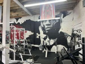 a gym with a wall with a mural of a man at Cozy Central Double Suite - Free Gym! in Leicester