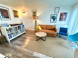 salon z kanapą, stołem i krzesłami w obiekcie Cosy Duplex avec Parking à Paris 19 by immo kit bnb w Paryżu