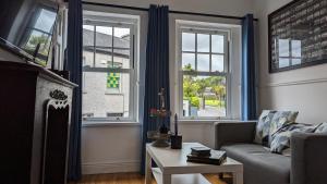 a living room with a couch and two windows at 1780 Green Street in Dingle