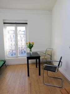 パリにあるMini Loft Roquette CityCosyのテーブルと椅子、窓が備わる客室です。