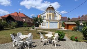 a group of tables and chairs in front of a house at Villa Vanília in Keszthely