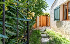 a fence with a large green plant next to a house at Amazing Apartment In Avignon With Wifi in Avignon