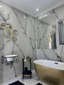 a bathroom with a tub and a sink at Golden Suite Apartment Summerstrand in Gqeberha +9 photos