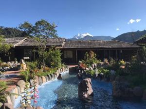 a pool in front of a house with a waterfall at Termas de Papallacta in Papallacta