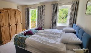 a bedroom with a bed and a large window at Plas Penaeldroch Manor in Dolwyddelan