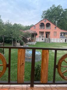 un aigle assis sur une balustrade devant une maison dans l'établissement Guest house and cellar MAMULI, à Tʼerjola 4 autres photos