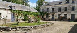 an old building with a stone wall next to a house at Studio Cosy Boxes Chevaux en sus in Agnez-lès-Duisans