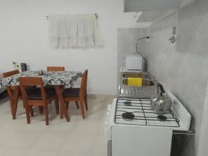 a kitchen with a stove and a table with chairs at Departamento Lucia in Trelew