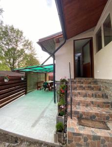 a house with a patio and a table with flowers at Gretas Home Surduc in Fîrdea +4 photos