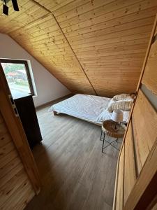 una cama en una habitación con techo de madera en Lazurowa Chata Rydzewo, en Rydzewo