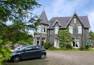 a car parked in front of a large house at Plas Penaeldroch Manor in Dolwyddelan