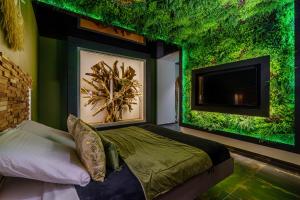 a bedroom with a green wall with a bed and a tv at Love Room Evasion Duo in Marseille