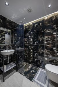 a bathroom with a shower and a sink and a toilet at Euphoria Apartments in Sarandë